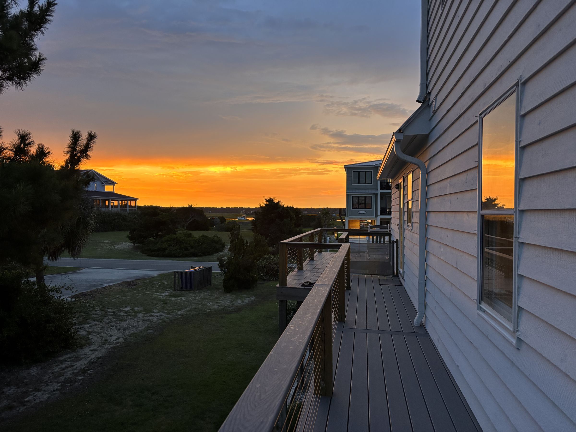 Sunset glowing orange over the marsh, seen from the home's deck on Oak Island
